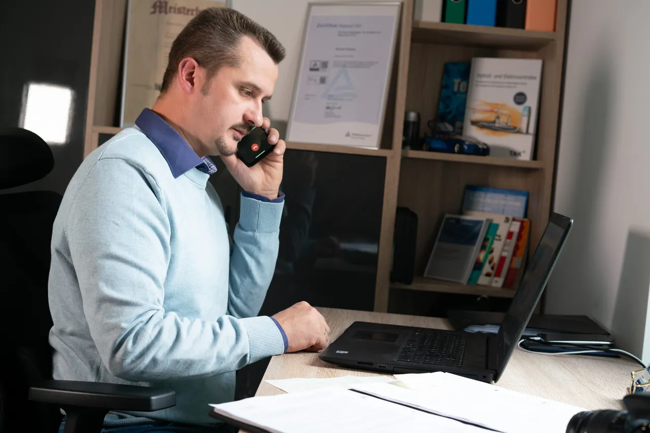 Roman Ebauer im Sachverständigenbüro am Telefon